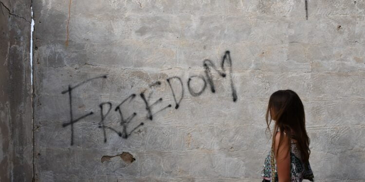 woman in black and white tank top leaning on wall